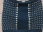 Saia preta com tachas douradas